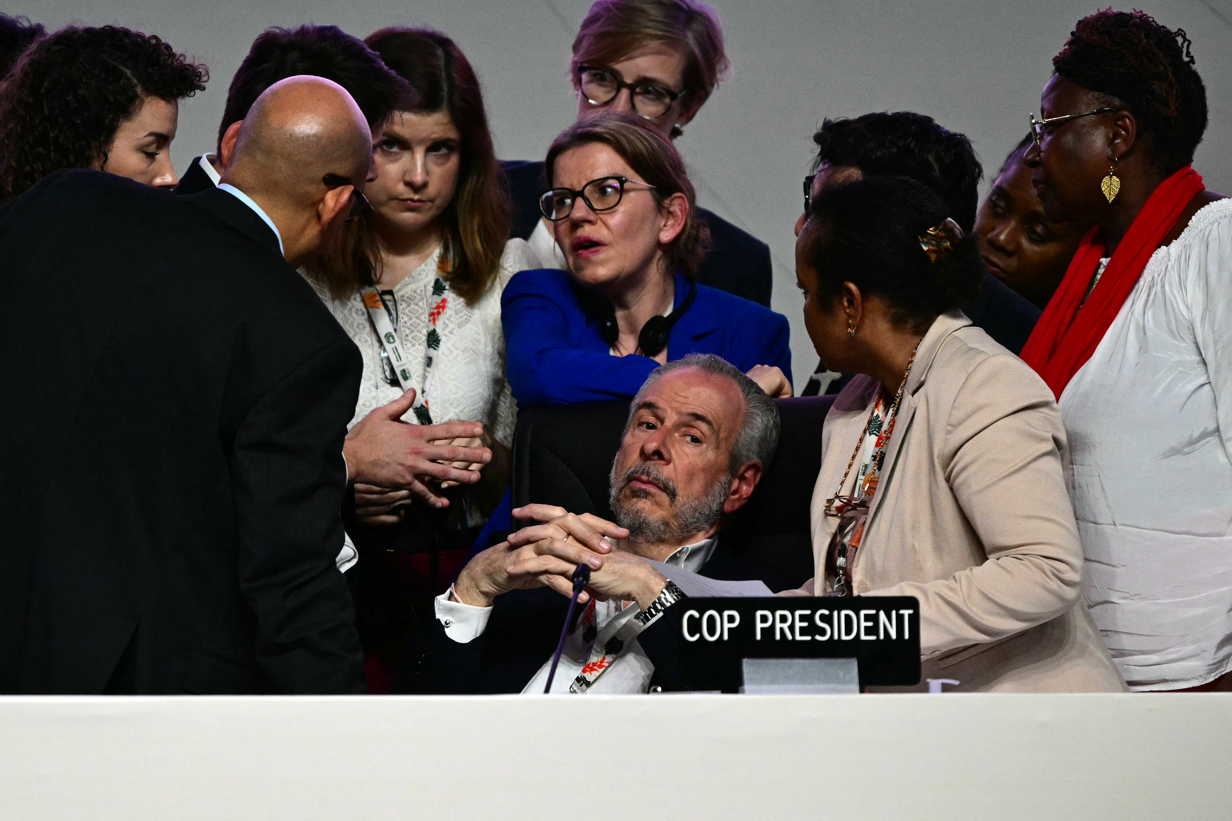 COP30 President Andre Correa do Lago (C) listens to his advisers next to United Nations Climate Change Executive Secretary Simon Stiell (L)