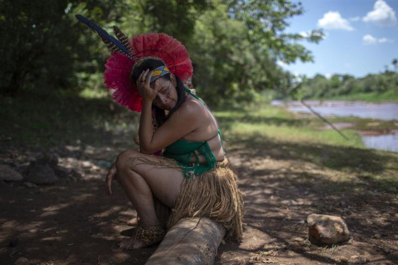 Uma indígena da comunidade Pataxó hã-hã-hãe chora ao olhar o rio Paraopeba coberto de lama, no sexto dia após o colapso de uma barragem em uma mina de ferro perto da cidade de Brumadinho. Mauro Pimentel/AFP